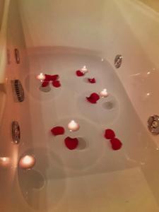 bañera llena de corazones rojos y velas en One bedroom property with wifi at Zaragoza, en Zaragoza