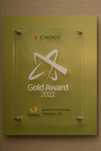 a sign for a gold award on a wall at Quality Inn & Suites in Lexington
