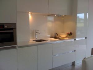 a white kitchen with a sink and a microwave at Apartamento con jardín in Barro de Llanes +8 photos