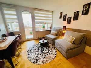 a living room with a couch and a table at Sunset View Apartment with Logia in Ettlingen