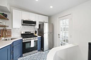 a kitchen with blue cabinets and a stainless steel refrigerator at Silverwood Serenity: Large 2b 2b with Parking in Philadelphia