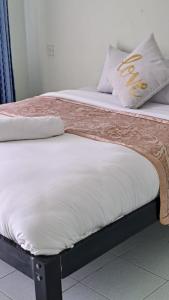 dos camas sentadas una al lado de la otra en una habitación en Tamiasuites Apartment, en Kisumu