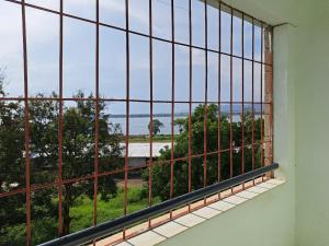 a window with a view of the ocean seen through it at Tamiasuites Apartment in Kisumu