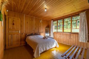 a bedroom with a bed in a wooden room at Pousada Morro Grande in Bom Jardim da Serra