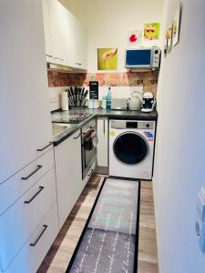 een keuken met een wasmachine en droger op de vloer bij Sunset View Apartment with Logia in Ettlingen
