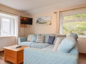 - un salon avec un canapé bleu et une fenêtre dans l'établissement The Hideaway, à St Austell