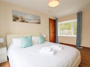 - une chambre avec un grand lit blanc et une fenêtre dans l'établissement The Hideaway, à St Austell