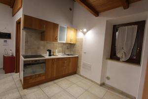 a kitchen with wooden cabinets and a sink and a window at Il Cottage di Stella incantevole appartamento in SantʼOreste