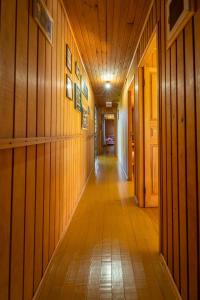 un couloir vide avec des panneaux de bois et un long couloir dans l'établissement Pousada Morro Grande, à Bom Jardim da Serra