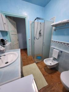 uma casa de banho com um lavatório, um chuveiro e um WC. em La brezza marina em SantʼAntìoco