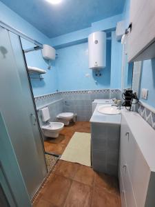 uma casa de banho azul com um WC e um lavatório em La brezza marina em SantʼAntìoco