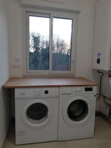 - un lave-linge et un sèche-linge dans une chambre avec fenêtre dans l'établissement Maison au cœur de la foret, à La Fontaine-Saint-Martin 6 autres photos