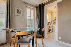 uma sala de jantar com uma mesa de vidro e cadeiras em One bedroom property with terrace and wifi at Courcelles em Courcelles