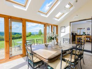 a dining room with a table and chairs and windows at 4 Bed in Llanidloes 51651 in Llandinam