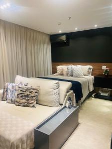 a hotel room with two beds and a couch at Itaim Bibi - The Capital Flat - Apto 1211 in Sao Paulo
