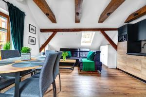 a dining room and living room with a table and chairs at Willa KAMELIA-apartamenty in Krynica Zdrój