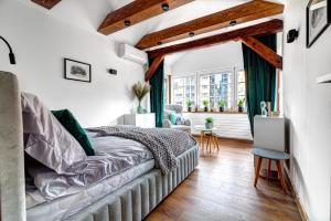 a bedroom with white walls and a bed and a window at Willa KAMELIA-apartamenty in Krynica Zdrój