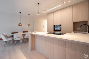 Una cocina con encimera y mesa con sillas. en Verliefd aan zee, en Knokke-Heist