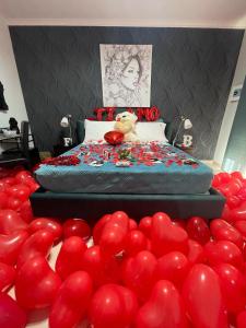 a bed with a bunch of red balloons around it at BRUMARI in Foggia