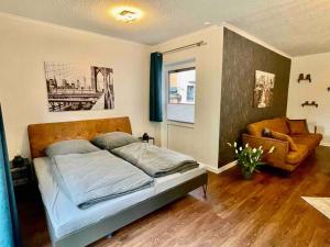 a bedroom with a bed and a chair in it at Studioappartement mit Privatgarten in ruhiger Wohnsiedlung in Neumünster