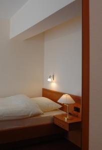 ein Schlafzimmer mit einem Bett und einer Lampe auf einem Tisch in der Unterkunft Altstadthotel-Rheine in Rheine