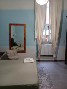 a bedroom with a bed and a mirror and a window at Piazza Verdi Liberty House in Lecce