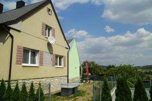 uma casa amarela e verde ao lado de uma cerca em Domek Šumava em Sušice