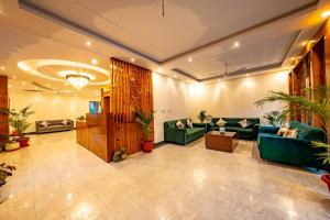 a lobby with green couches and potted plants at The Himalayan Stays Nainital in Nainital