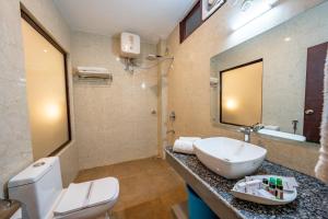 a bathroom with a white toilet and a sink at The Himalayan Stays Nainital in Nainital