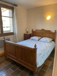 a bedroom with a wooden bed and a window at Appartement T3 avec vue sur le lac in Chorges