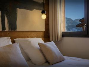 La Cornette - OVO Network في لي جيه: سرير مع وسائد بيضاء في غرفة نوم مع نافذة