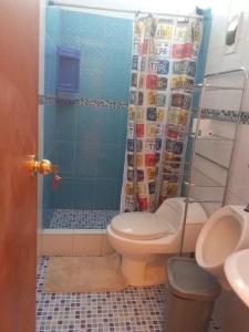y baño con aseo y cortina de ducha. en El amanecer, en Cajamarca