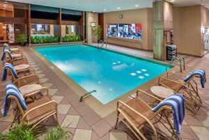 a large swimming pool in a hotel room with chairs at DoubleTree by Hilton Philadelphia Airport in Philadelphia