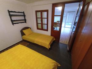 a room with two beds with yellow sheets in it at Apartments Villa Marta - Begovic in Kotor