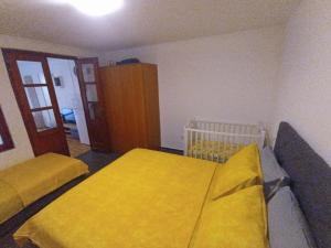 1 Schlafzimmer mit 2 Betten und gelber Bettwäsche in der Unterkunft Apartments Villa Marta - Begovic in Kotor