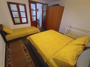 2 Betten in einem Zimmer mit gelber Bettwäsche in der Unterkunft Apartments Villa Marta - Begovic in Kotor
