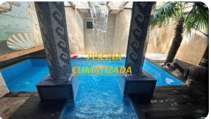 a swimming pool with a water fountain in a building at Hotel Casa Rural SPA La Villa in Ávila