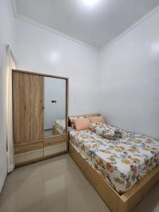 1 dormitorio con cama y espejo grande en Villa Jingga Joyogrand Malang, en Malang