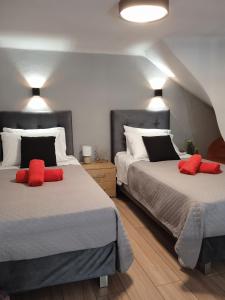 een slaapkamer met 2 bedden en rode kussens bij Nicol studio for two center of Agios Nikolaos in Agios Nikolaos