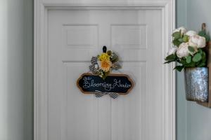 ein Schild an einer Tür mit einer Blume darauf in der Unterkunft Grand Mansion-Blooming Garden suite! in Fort Smith
