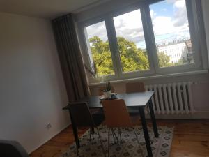 a dining room with a table and chairs in front of a window at Irra Apartment in Gdańsk