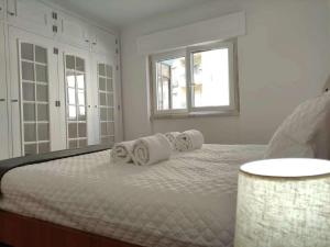 Un dormitorio blanco con una cama con toallas. en Spacious 26, en Agualva