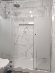 y baño con ducha y puerta de cristal. en Spacious 26, en Agualva