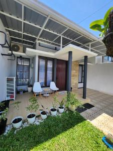 un patio con plantas y sillas en una casa en Villa Jingga Joyogrand Malang, en Malang