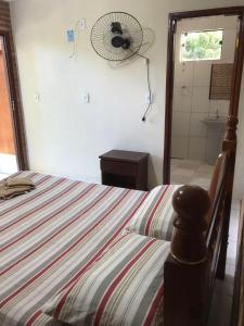 a bedroom with a bed and a fan on the wall at Pousada Sitio Urbano in São José da Barra