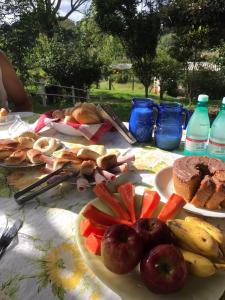 einen Tisch mit Teller mit Lebensmitteln und Obst darauf in der Unterkunft Pousada Sitio Urbano in São José da Barra