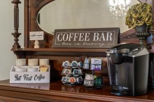 a coffee bar with a coffee maker on a counter at Grand Mansion-Blooming Garden suite! in Fort Smith