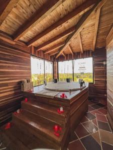 uma casa de banho com banheira numa casa de madeira em Cabaña con Jacuzzi ilimitado/BBQ/Hermosas vistas em San Vicente