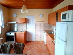 una cucina con armadi in legno e frigorifero bianco di Vila Caba a Křemže