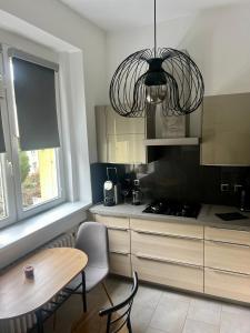 eine Küche mit einem Tisch und einem Kronleuchter in der Unterkunft Apartmán l Praha centrum in Prag
